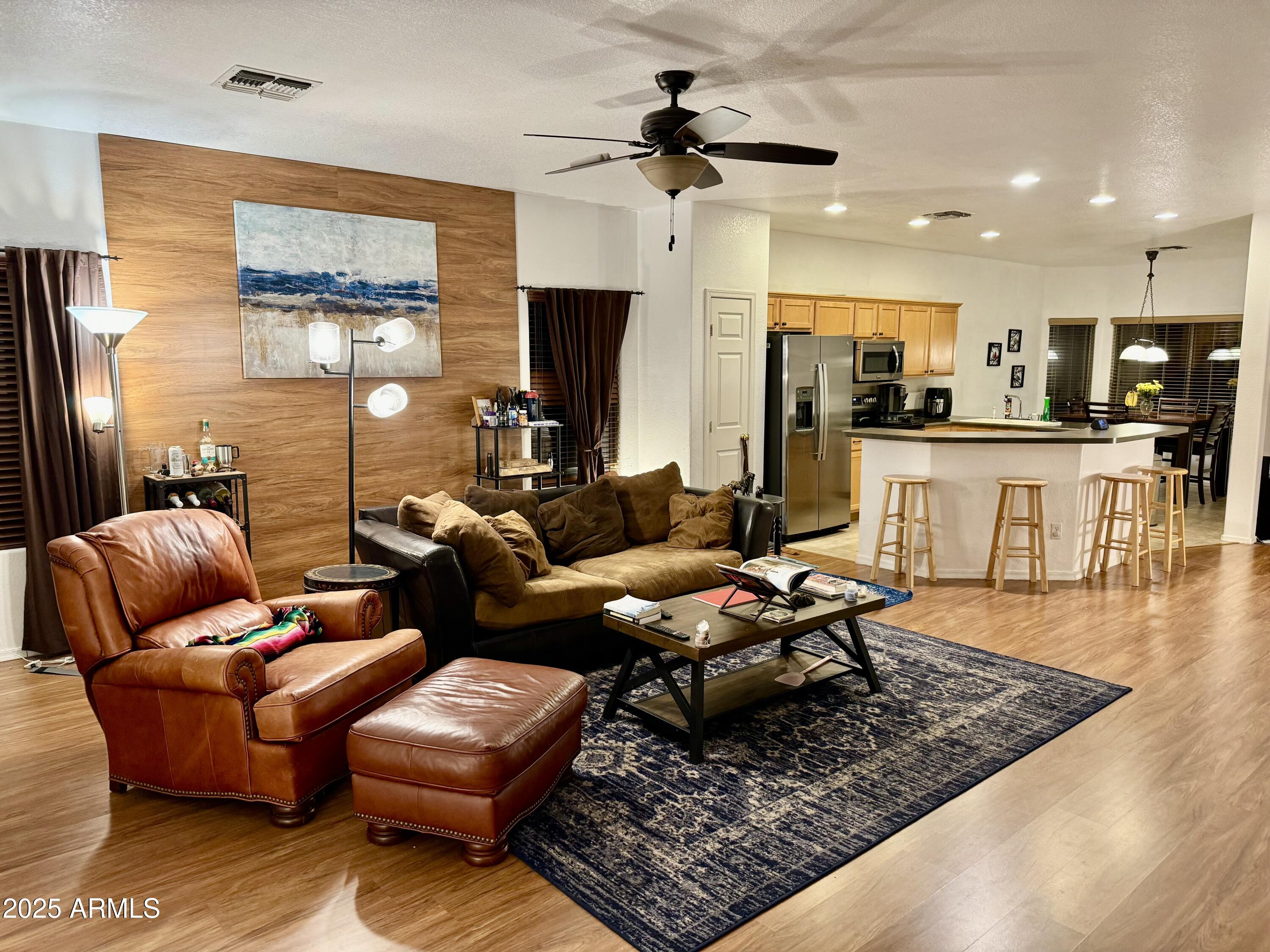 12542 West Honeysuckle Street Litchfield Park, AZ 85340 - Photo 4 of 19 a living room with furniture wooden floor and a view of kitchen