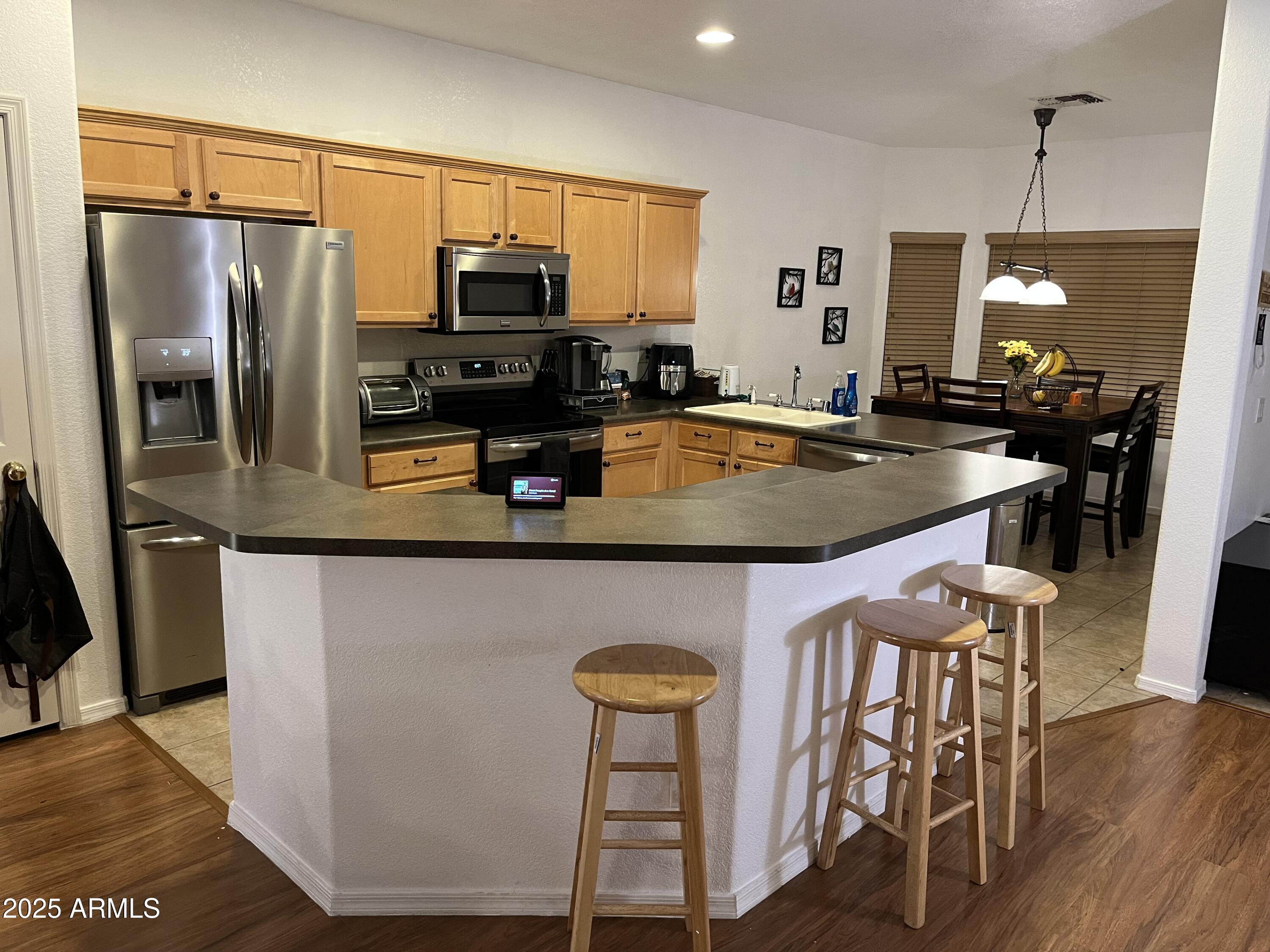 12542 West Honeysuckle Street Litchfield Park, AZ 85340 - Photo 6 of 19 a kitchen with stainless steel appliances granite countertop a sink a stove and a refrigerator