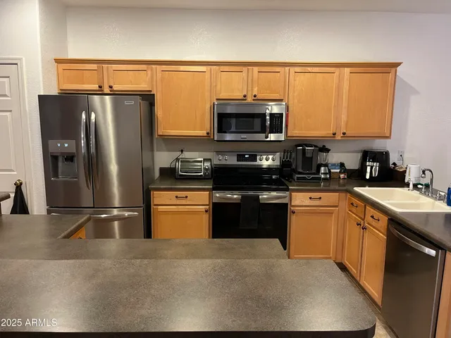 a kitchen with stainless steel appliances granite countertop a refrigerator stove top oven a sink and dishwasher