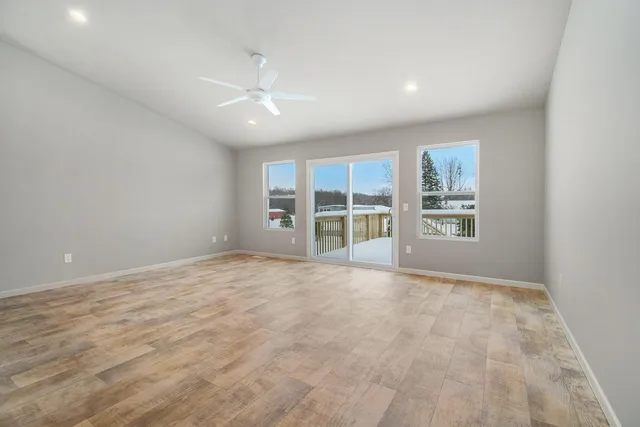 an empty room with windows and fireplace