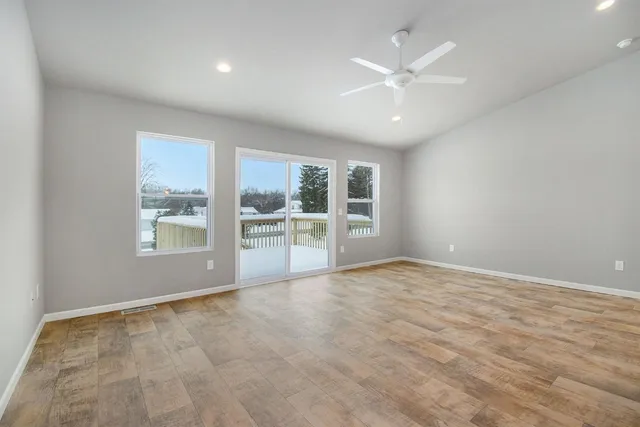 an empty room with fan and windows