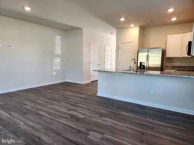 a kitchen with wooden floors and stainless steel appliances