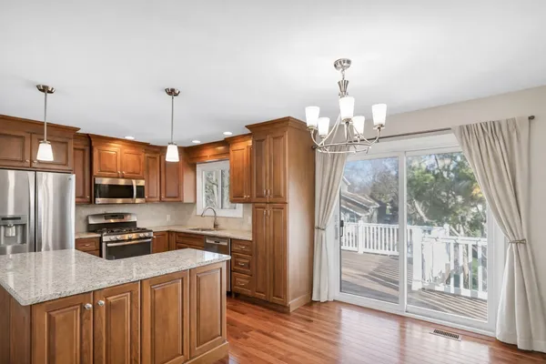 a kitchen with stainless steel appliances a refrigerator a stove a sink and a chandelier