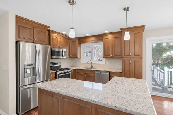 a kitchen with stainless steel appliances granite countertop a refrigerator a sink and a stove