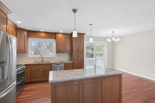 a kitchen with granite countertop a sink a counter space appliances and cabinets