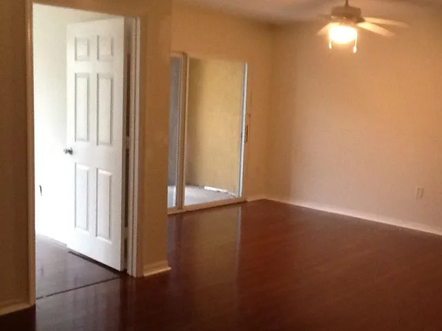 an empty room with wooden floor and windows