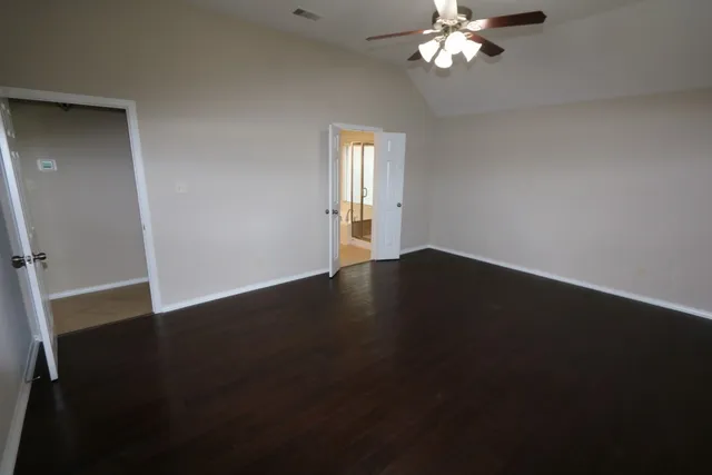 a view of wooden floor and a chandelier fan in a room