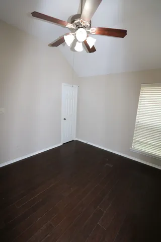 a view of wooden floor and a chandelier fan in a room