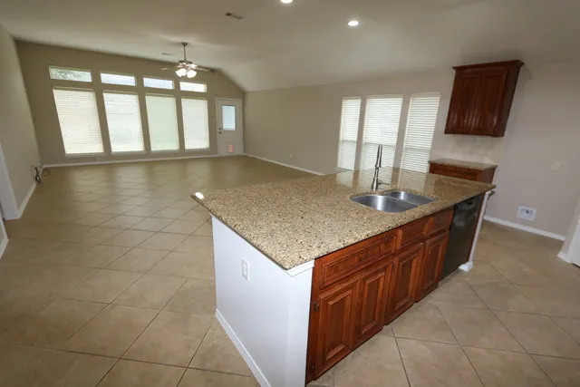 a kitchen with stainless steel appliances granite countertop a sink counter space and a window