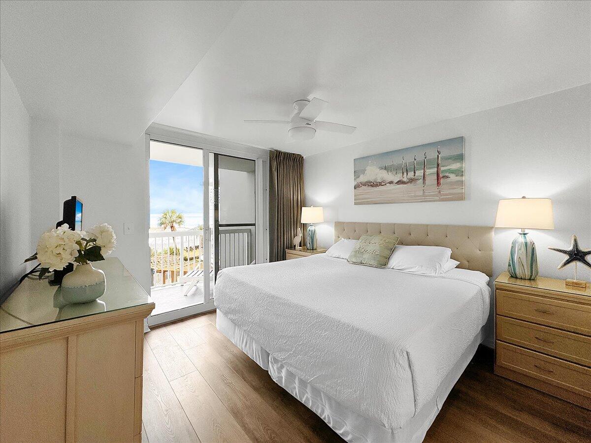 1002 Highway 98, Unit 316 Destin, FL 32541 - Photo 13 of 31 a spacious bedroom with a bed and a chandelier
