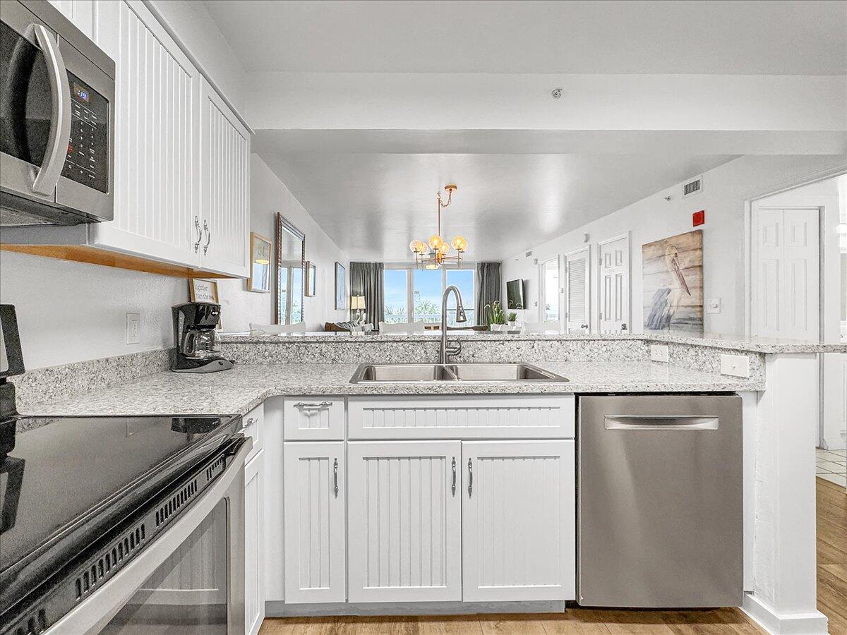 1002 Highway 98, Unit 316 Destin, FL 32541 - Photo 5 of 31 a kitchen with a sink stove and cabinets