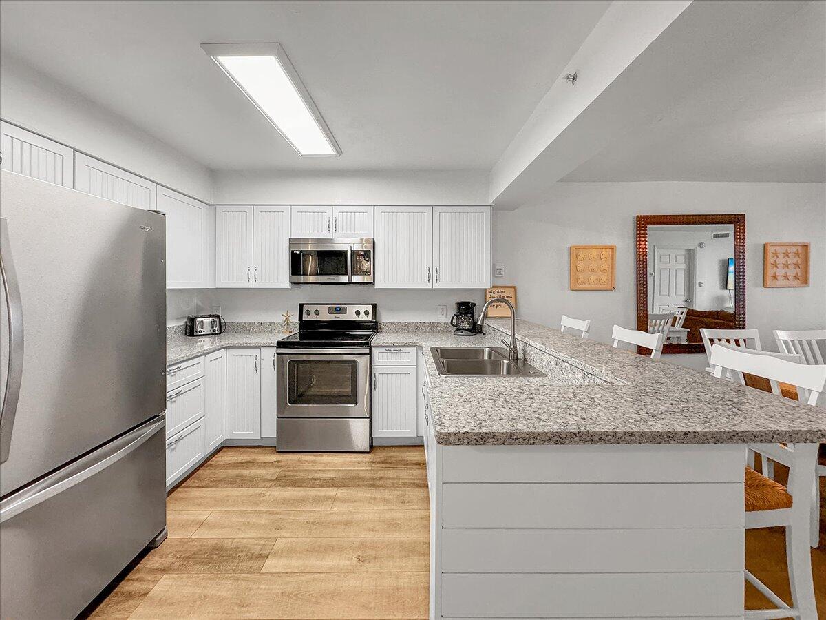 1002 Highway 98, Unit 316 Destin, FL 32541 - Photo 7 of 31 a kitchen with granite countertop a refrigerator stove and sink