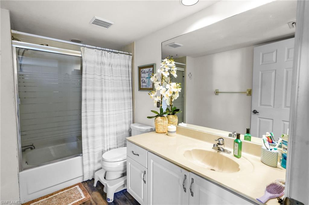 601 Augusta Boulevard, Unit 10 Naples, FL 34113 - Photo 13 of 27 Bathroom featuring vanity, shower / tub combo, and dark wood-type flooring