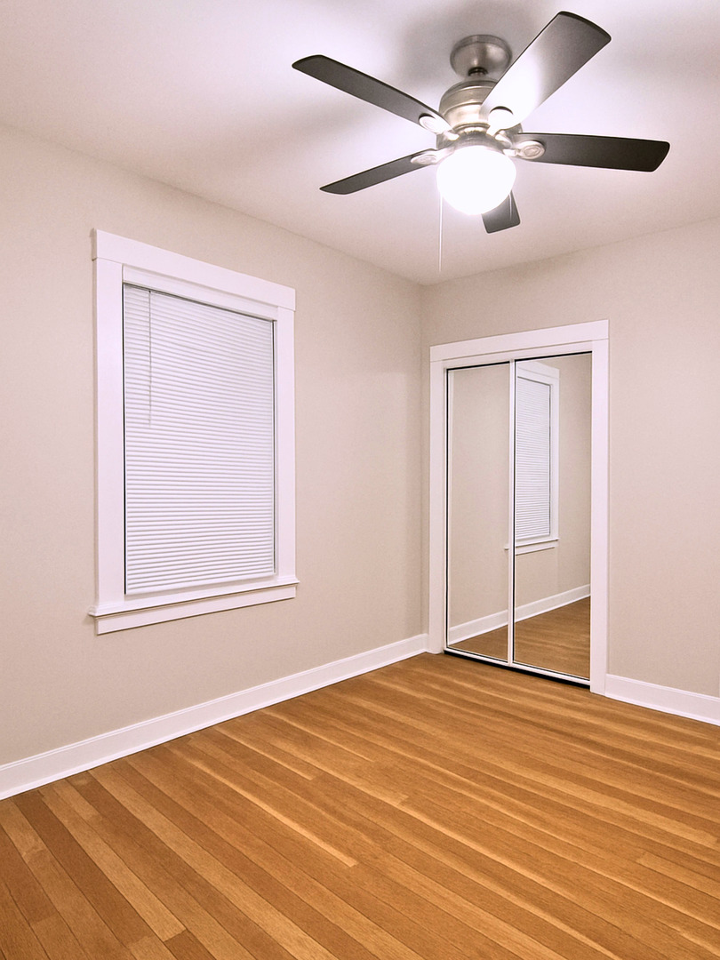 4701 North Kilbourn Avenue, Unit 2 Chicago, IL 60630 - Photo 6 of 13 a view of an empty room with wooden floor and a ceiling fan