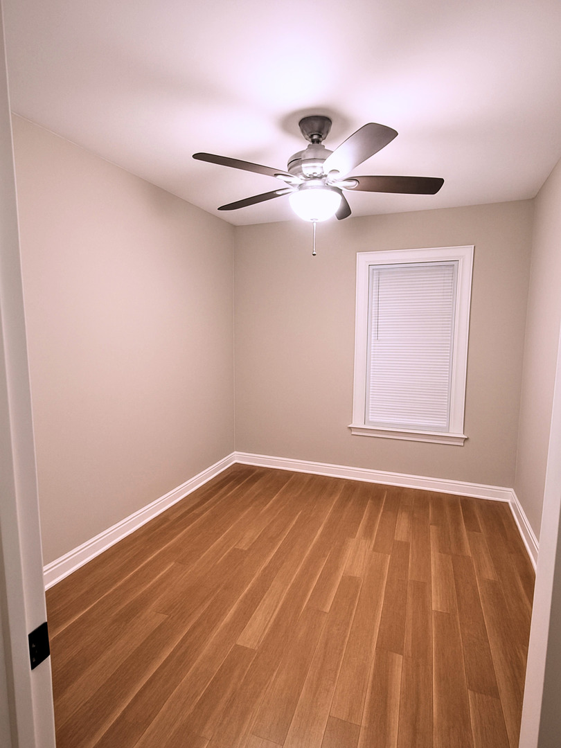 4701 North Kilbourn Avenue, Unit 2 Chicago, IL 60630 - Photo 7 of 13 a view of an empty room with wooden floor and a window