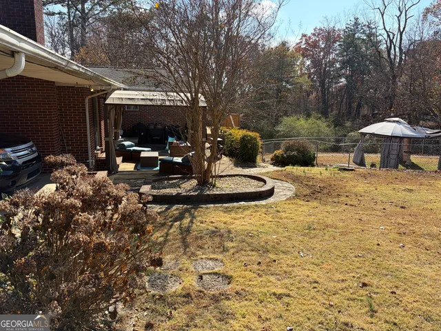 a view of backyard with wooden fence