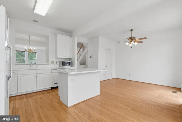 a kitchen with a sink cabinets and wooden floor