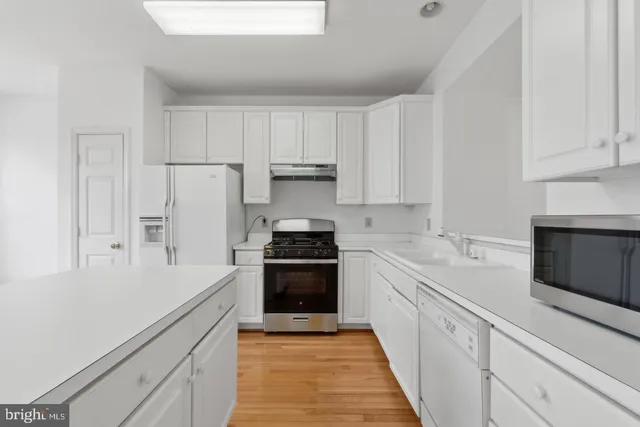 a kitchen with white cabinets and stainless steel appliances