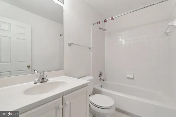 a bathroom with a double vanity sink mirror and bathtub