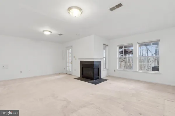 an empty room with a fireplace and a window