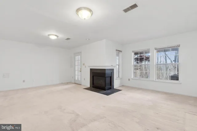 an empty room with a fireplace and a window