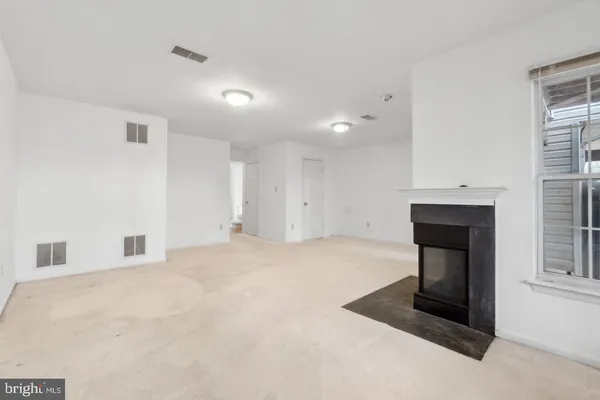 a view of empty room with a fireplace and window