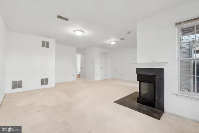 a view of empty room with a fireplace and window