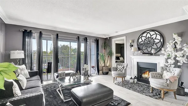 a living room with furniture a large window and a fireplace