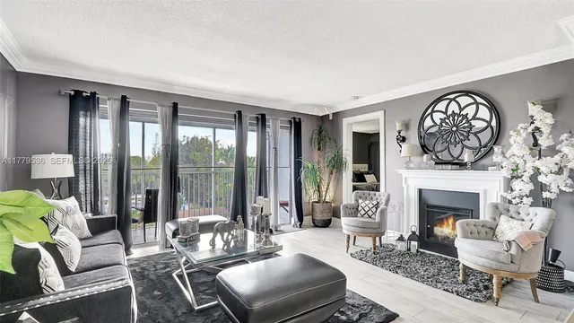 a living room with furniture a large window and a fireplace