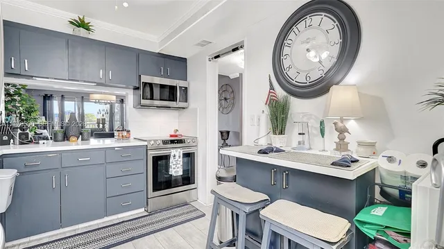 a kitchen with a stove a sink a stove and a clock