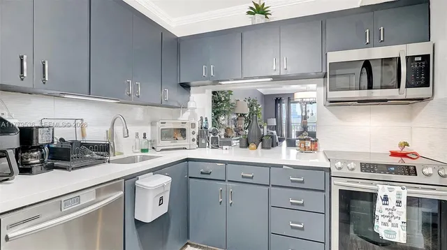 a kitchen with stainless steel appliances granite countertop a sink and a stove