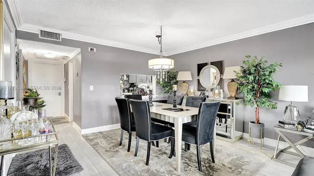 a view of a dining room with furniture and chandelier