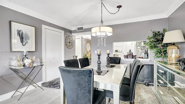 a view of a dining room with furniture a chandelier and wooden floor