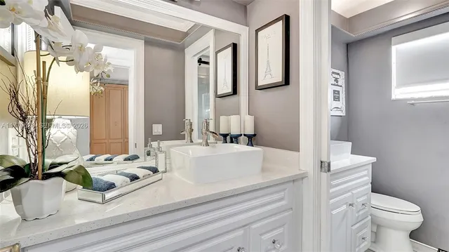 a bathroom with a sink mirror and toilet