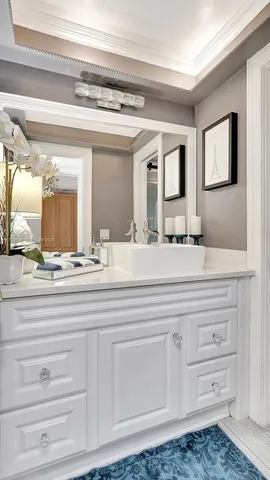 a bathroom with white cabinets and a sink