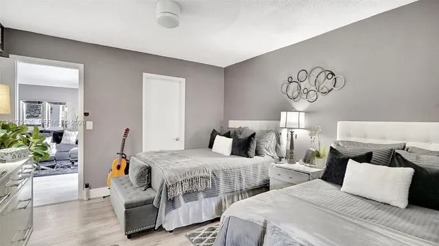 a bedroom with two beds and potted plant