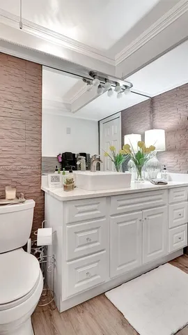 a bathroom with a sink a toilet and mirror