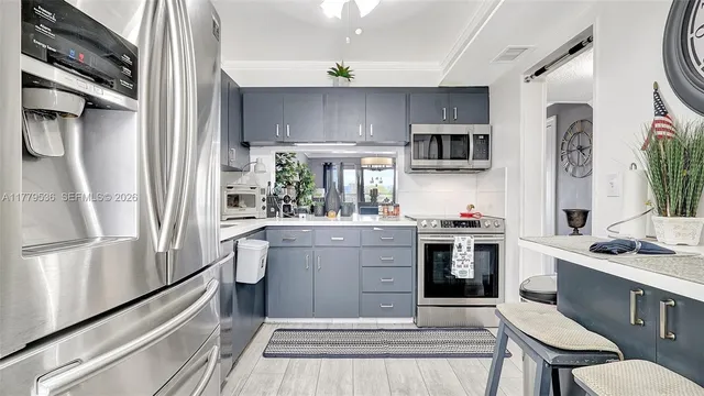 a kitchen with stainless steel appliances a stove a sink and a refrigerator