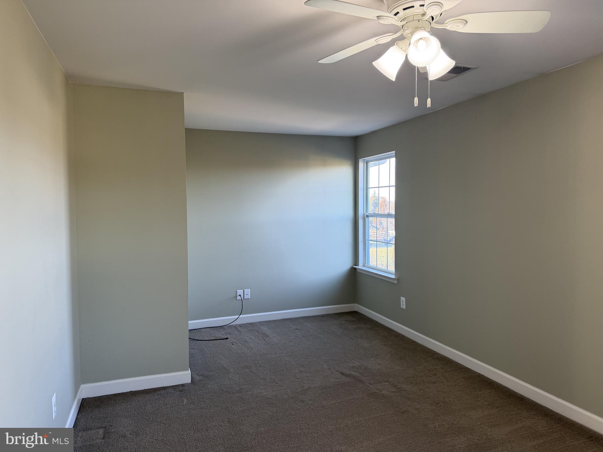 40 Loder Drive Smyrna, DE 19977 - Photo 18 of 29 an empty room with a chandelier fan and windows