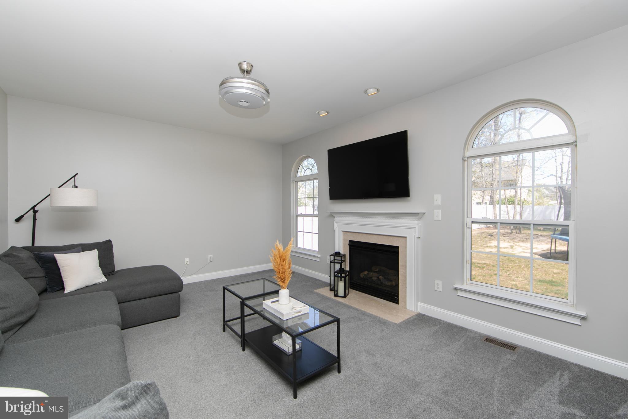 4 Conifer Way Sicklerville, NJ 08081 - Photo 11 of 39 a living room with furniture a flat screen tv and a fireplace