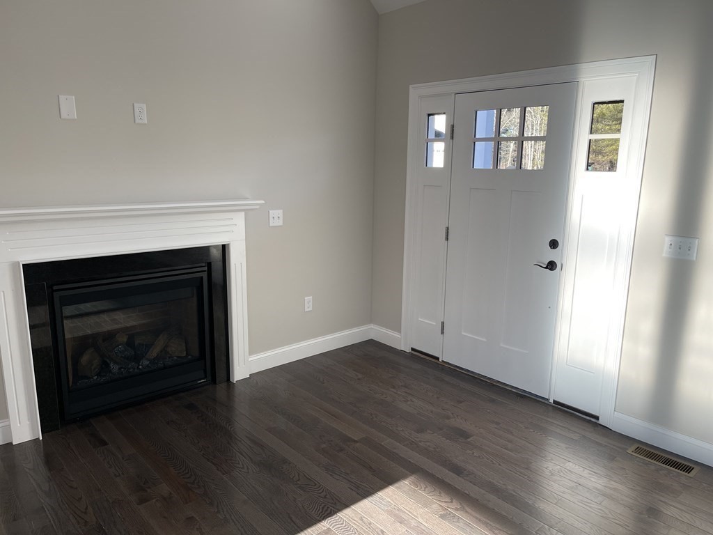 158 Snipatuit Road Rochester, MA 02770 - Photo 6 of 39 an empty room with wooden floor fireplace and windows