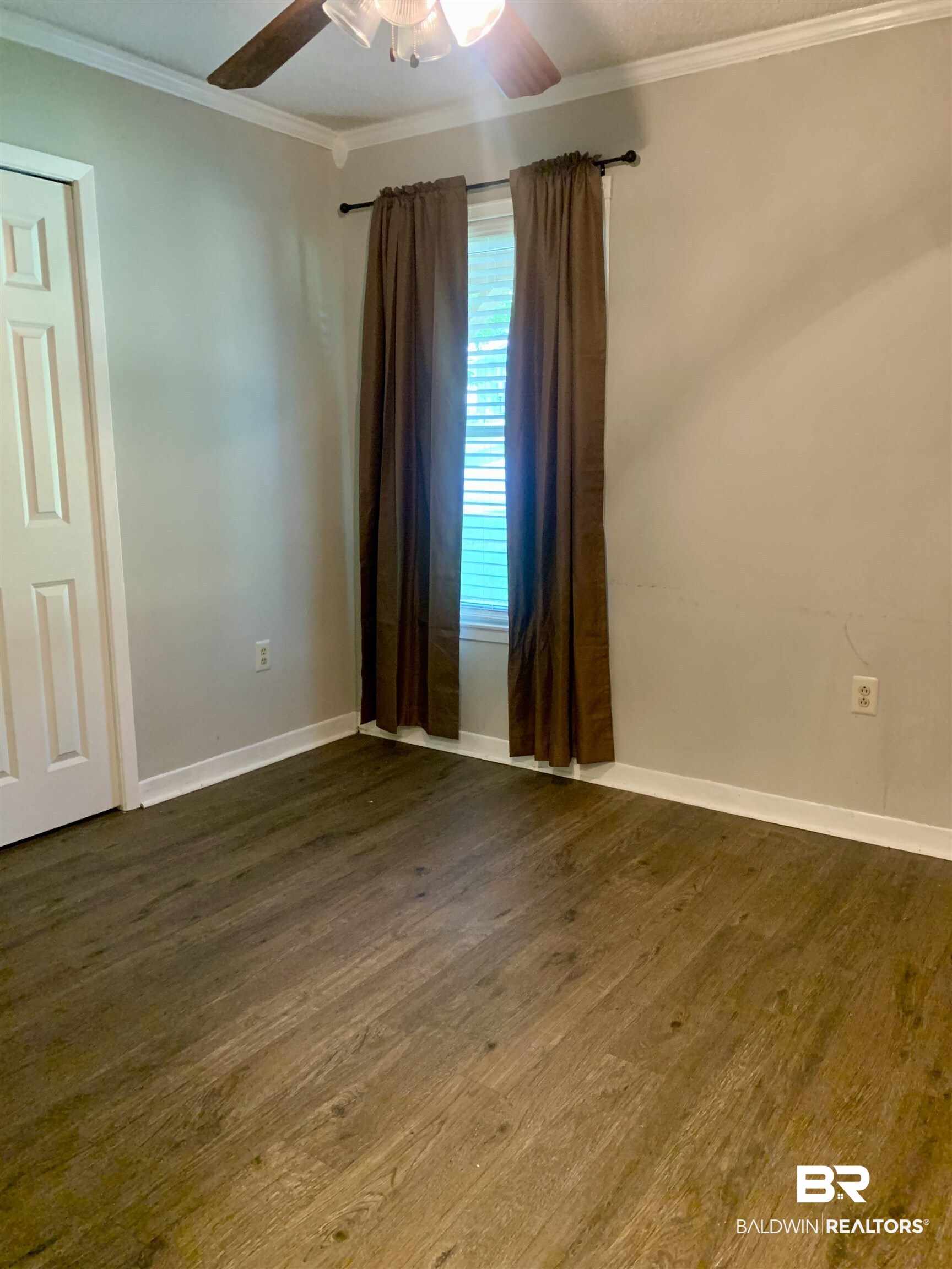 2708 E Road Mobile, AL 36693 - Photo 6 of 12 Unfurnished room featuring dark wood-type flooring, ornamental molding, and ceiling fan