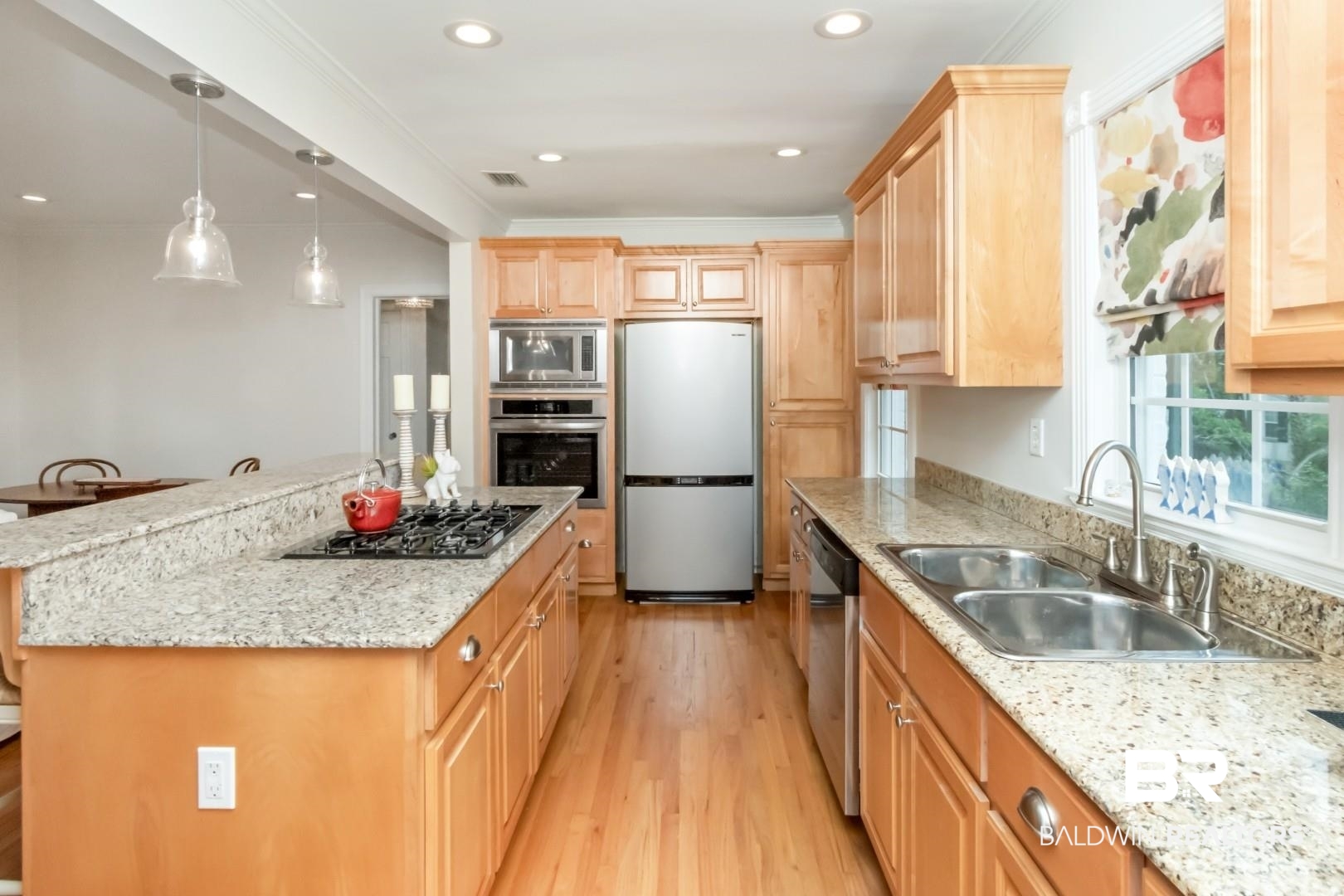 214 Upham Street, Unit 3D Mobile, AL 36607 - Photo 11 of 34 Kitchen featuring stainless steel appliances, light stone counters, light wood finished floors, light wood finish cabinets, and ornamental molding