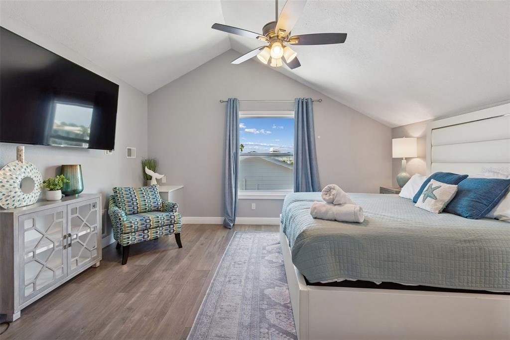 330 6th Avenue Indian Rocks Beach, FL 33785 - Photo 28 of 52 a bedroom with a bed a couch and a flat screen tv