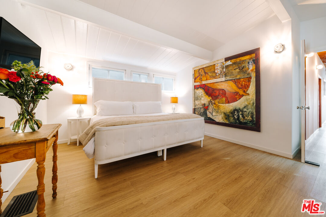 936 Palisades Beach Road Santa Monica, CA 90403 - Photo 11 of 31 a bedroom with a bed painting on wall and a potted plant
