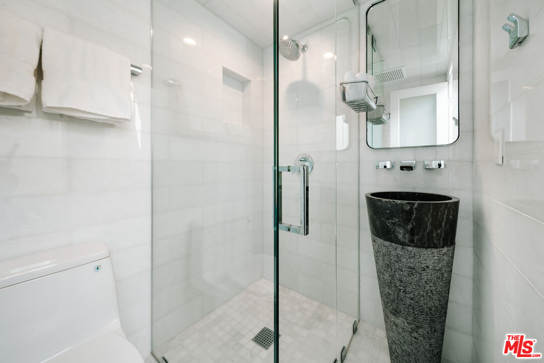 936 Palisades Beach Road Santa Monica, CA 90403 - Photo 14 of 31 a bathroom with a sink a mirror a vanity and a shower