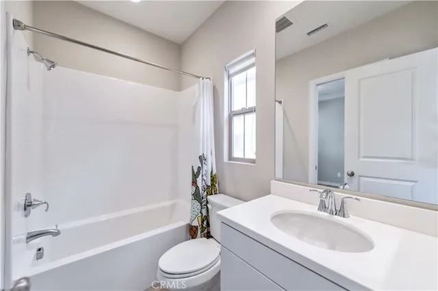 a bathroom with a bathtub shower sink vanity mirror and toilet