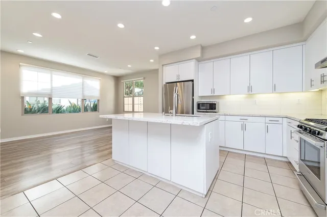a kitchen with stainless steel appliances granite countertop a refrigerator and a stove top oven
