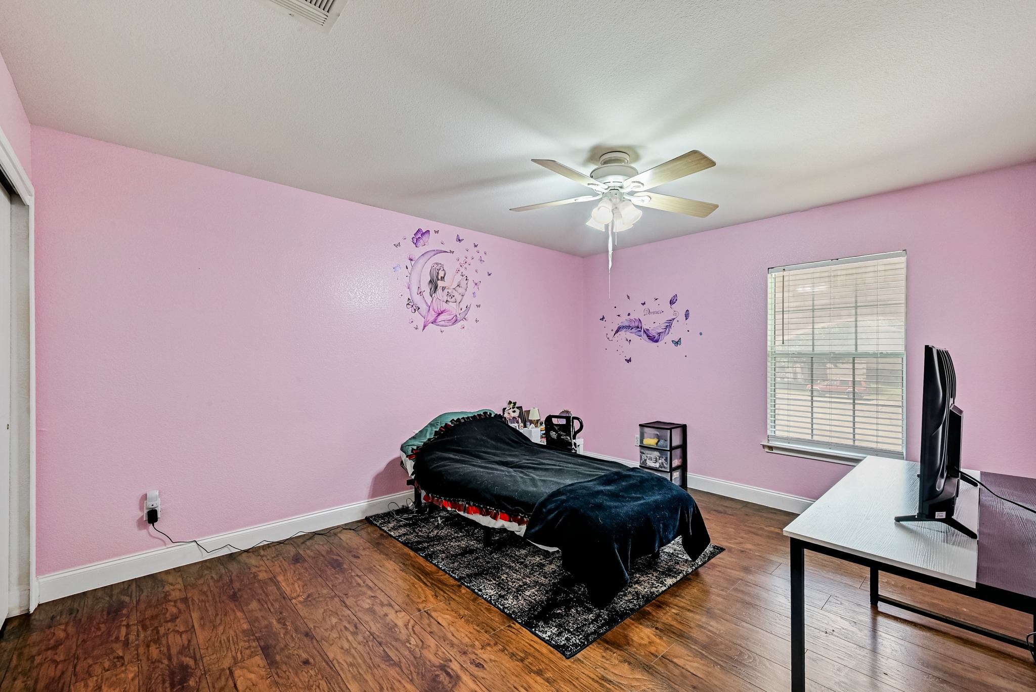 104 North Sumac Lane Georgetown, TX 78633 - Photo 35 of 40 Hardwood floors and a bright window elevate this comfortable bedroom space.