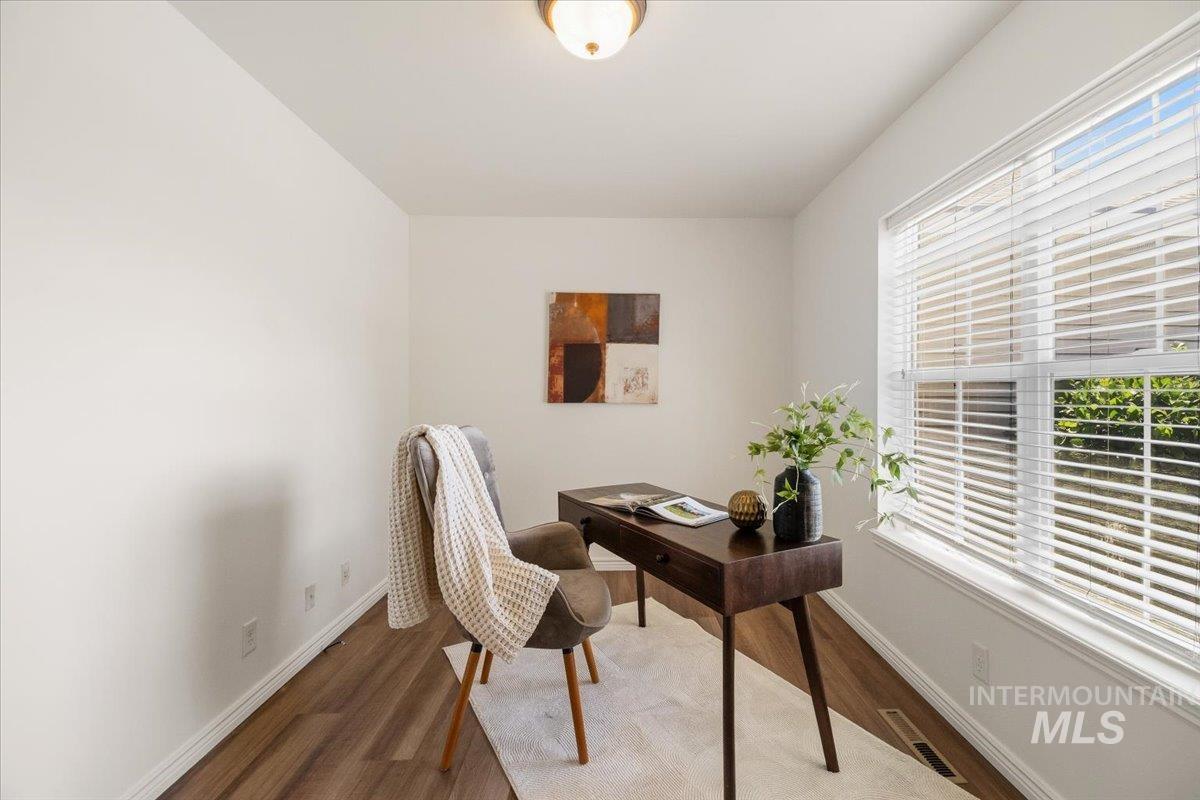 2032 Talus Loop Twin Falls, ID 83301 - Photo 8 of 43 Bright room featuring a large window with white blinds, wood-finish flooring, and white baseboards